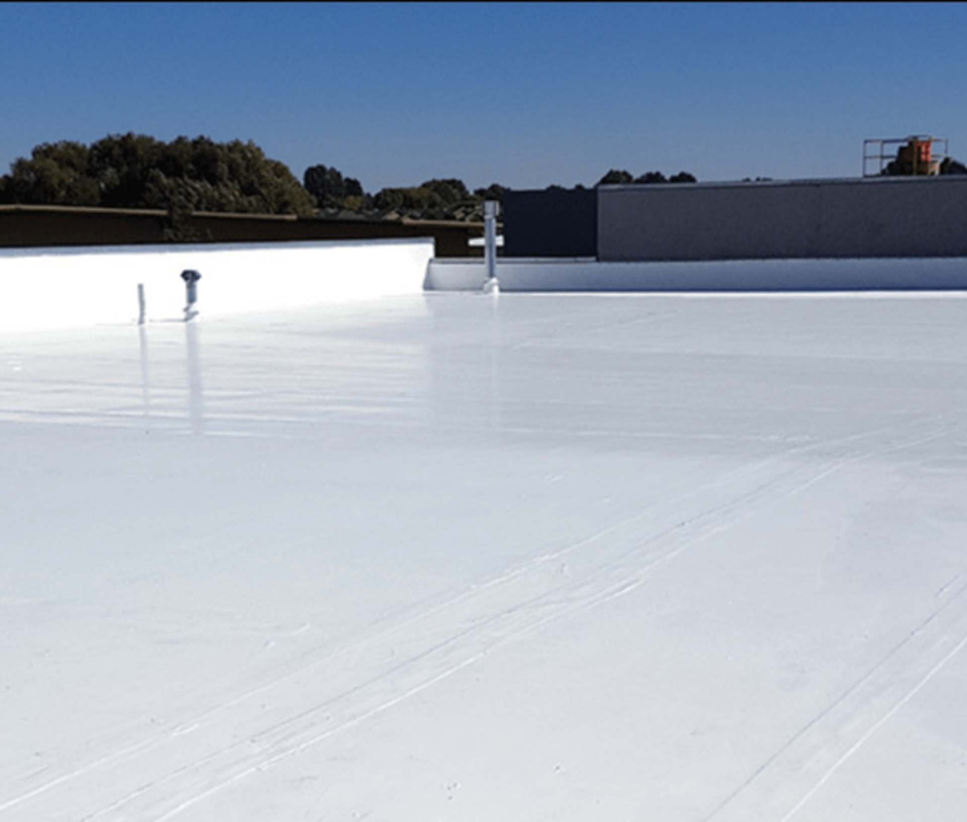 Finished white waterproofed terrace roof with mechanical equipment and clear sky