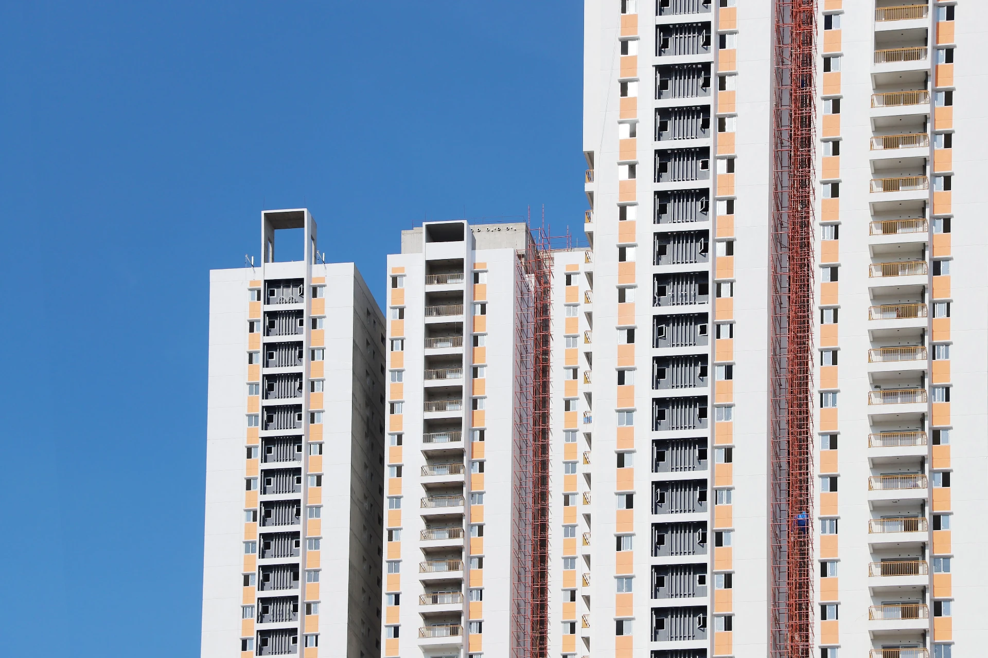 High-rise towers wrapped in façade scaffolding during structural restoration